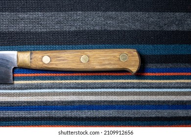 Wool fabric knitted with horizontal lines and knife handle visible.