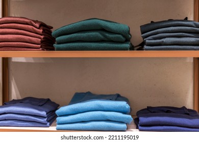 Wool Jumpers In Different Colors On The Wooden Shelves Of The Store. New Autumn Winter Collection. Close-up. Front View.