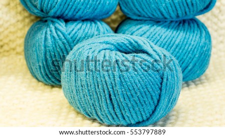 Wool in a tangle in turquoise on a knitted background