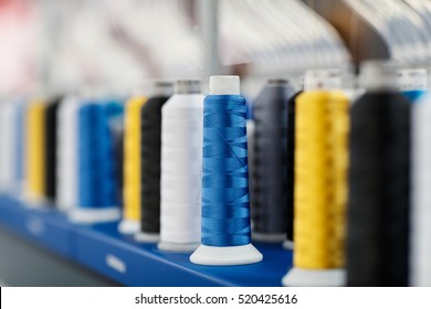 Wool and thread spools on desk used in textile industry
