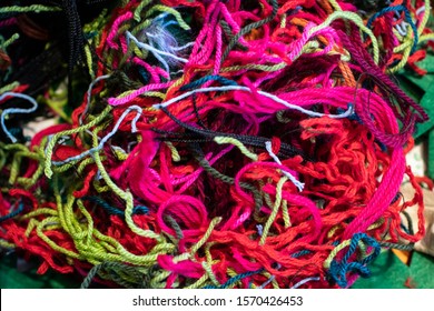 Wool Threads With Many Colors Woven Together To Form A Texture Of Lines. Abstract Background Composed Of Woven Wool And Cotton Threads, A Messy Pink Ball Of Yarn. Chaotic , Complicated Representation