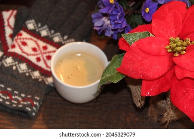 Woolen gloves, a cup of coffee and a Christmas poinsettia - Powered by Shutterstock