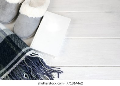 Woolen Warm Blanket, Book And  Cozy Home Slippers On Wooden Background. Relax And Stay At Home Concept. Copy Space.