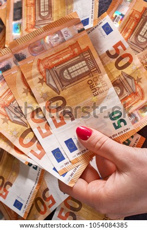 woomen's hand 50 fifty euros bills banknotes on money background