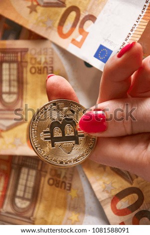 woomen's hand with bitcoin and 50 fifty euros of backgrounds bills banknotes