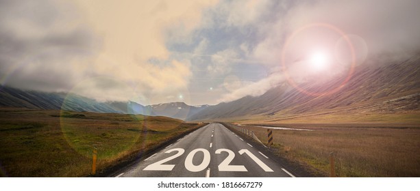 The Word 2021 Written On Highway Road In The Middle Of Empty Asphalt Road At Golden Sunset And Beautiful Blue Sky.