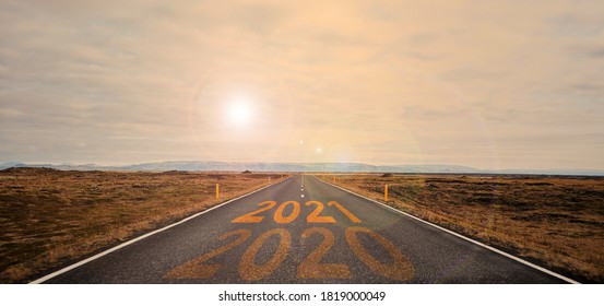 The Word 2021 Written On Highway Road In The Middle Of Empty Asphalt Road At Golden Sunset And Beautiful Blue Sky.