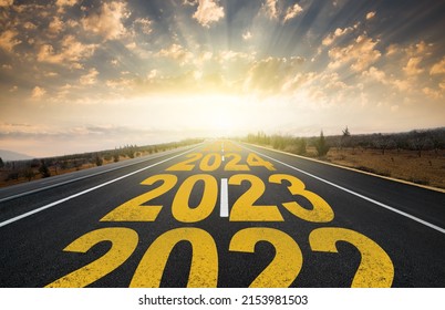 The word 2023 written on highway road in the middle of empty asphalt road at golden sunrise. New year 2023 concept. Concept of planning and challenge, business strategy, new life change - Shutterstock ID 2153981503