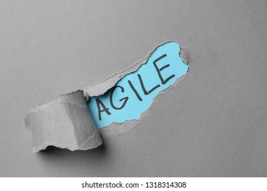 Word AGILE Visible Through Torn Paper