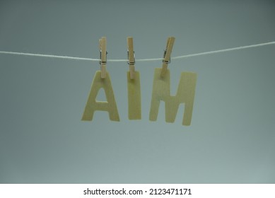 Word 'Aim' on white background. 'Aim' is defined as the point, target, direction, person or thing that is meant to be hit or achieved. Concept for learning, education, and preschool.