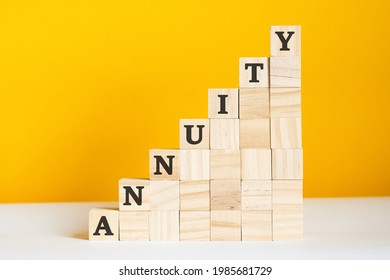 The Word Annuity Is Written On A Wooden Cubes. Blocks On A Bright Yellow Background. Corporate Hierarchy Concept And Multilevel Marketing. Selective Focus.