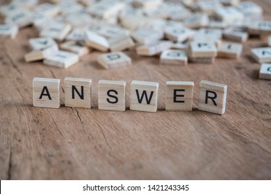 the word answer written with cube letters on wooden background