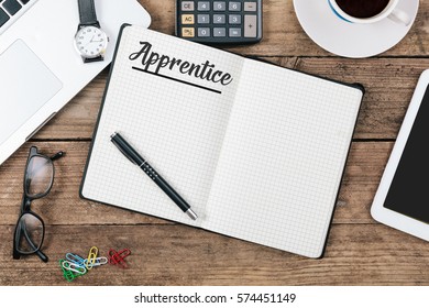Word Apprentice on note pad; Office desk with electronic devices, computer and paper, wood table from above, concept image for blog title or header image.