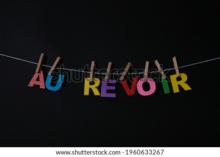 Word Au Revoir on black background. Au Revoir  means good bye in French. Concept for art, learning, and education.
