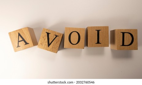 The word AVOID was created from wooden cubes. Consumption and shopping. Close-up. - Shutterstock ID 2032760546