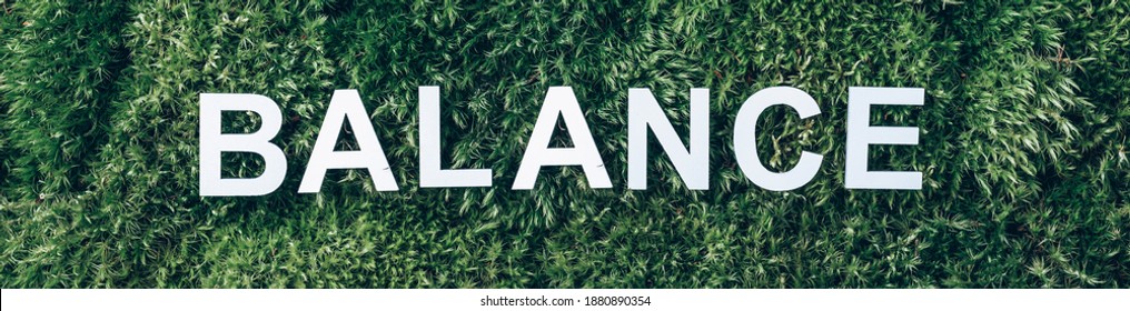 Word Balance on moss, green grass background. Top view. Copy space. Banner. Biophilia trend. Nature backdrop. Work Life Balance. Business work life concept. Body, soul, mind.