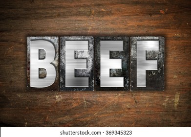 The word "Beef" written in vintage metal letterpress type on an aged wooden background.