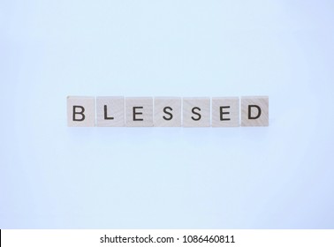 The Word Blessed Written With Wooden Squares And Isolated On A White Background.