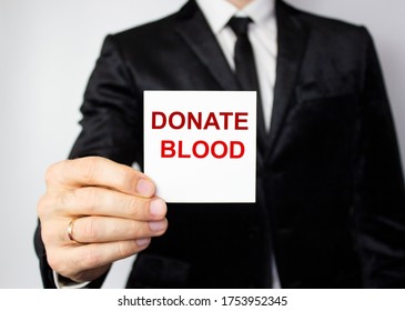 The word blood donation medical concept written in red letters on a white piece of paper in the hands of a businessman. - Shutterstock ID 1753952345