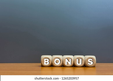Word bonus cube wood on wooden table gray background.
Concept bonus is any financial compensation.  - Shutterstock ID 1265203957