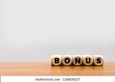 Word bonus cube wood on wooden table white background.
Concept bonus is any financial compensation.  - Shutterstock ID 1266036217