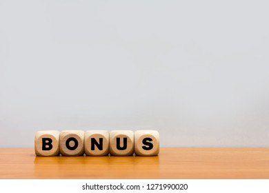 Word bonus cube wood on wooden table white background.
Concept bonus is any financial compensation.  - Shutterstock ID 1271990020