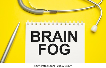 The Word Brain Fog Written On A White Notepad On A Yellow Background