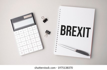 The Word Brexit Is Written On A White Background Next To A Pen ,calculator And Reports. Business Concept