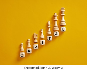 The Word Capital On Wooden Cubes With Chess Pieces. To Increase Capital Accumulation Concept.