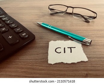 Word CIT with pen, calculator and glasses on office desk, polish corporate income tax, business, finance and strategy concept - Shutterstock ID 2110571618