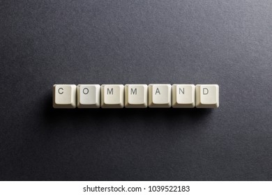 Word command made using computer keyboard buttons on a black background. IT technology concept.