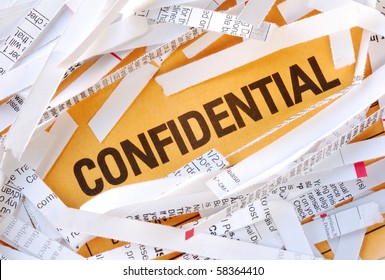 The Word Confidential Surrounded By Some Shredded Papers