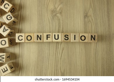 Word confusion from wooden blocks on desk - Shutterstock ID 1694534104