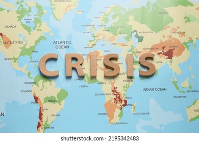 Word Crisis Made Of Wooden Letters On World Map, Flat Lay