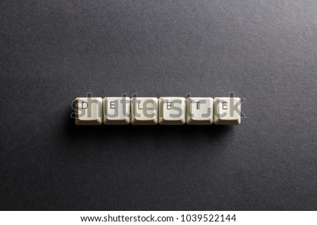 Word delete made using computer keyboard buttons on a black background. IT technology concept.