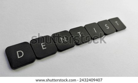 Word DENTIST spelled with black plastic letters on a white background