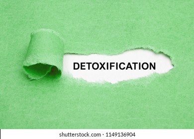 The word Detoxification appearing behind ripped green paper.