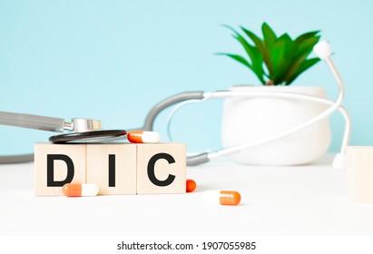 The word dic is written on wooden cubes near a stethoscope on a wooden background. Medical concept - Shutterstock ID 1907055985