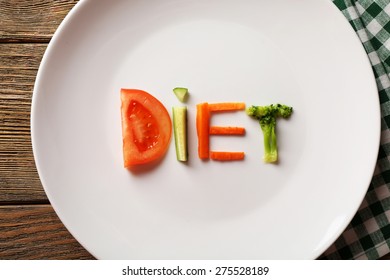 Word DIET Made Of Sliced Vegetables On White Plate With Napkin, Closeup