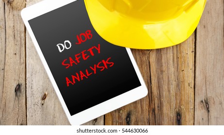 Word Do Job Safety Analysis On Tablet With Yellow Safety Helmet On Wooden Base.Safety Conceptual