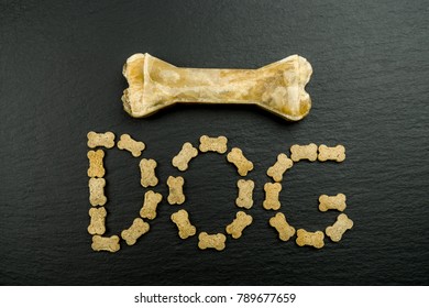 The Word Dog With Little Dog Treats And A Big Bone On Black Background