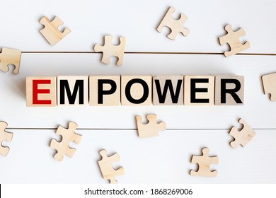 The word Empower written in a wooden cube NEAR WOODEN PUZZLES