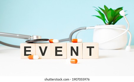 The Word EVENT Is Written On Wooden Cubes Near A Stethoscope On A Wooden Background. Medical Concept