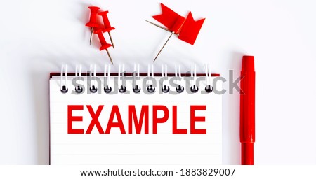 The word EXAMPLE is written in the notebook with office tools . Business concept