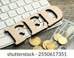 Word Fed (Federal Reserve System) made with letters, keyboard, dollar banknotes and coins on wooden table, closeup