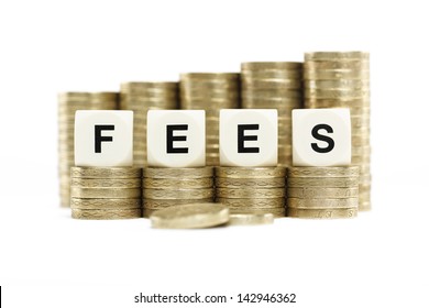 The word FEES on stacks of gold coins on a white background 