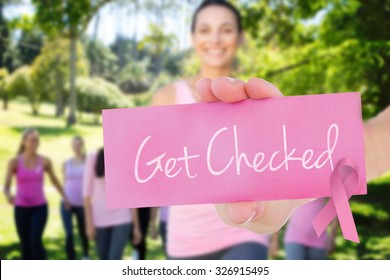 The Word Get Checked And Young Woman Holding Blank Card Against Smiling Women In Pink For Breast Cancer Awareness