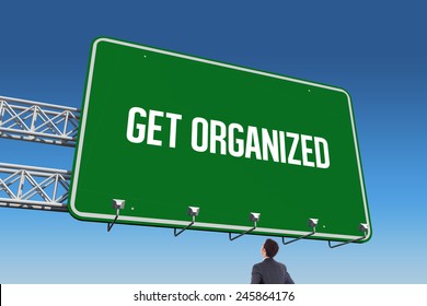 The word get organized and businessman standing with hands on hips against blue sky - Powered by Shutterstock
