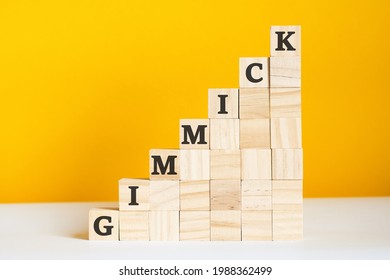 the word gimmick is written on a wooden cubes. blocks on a bright yellow background. corporate hierarchy concept and multilevel marketing. selective focus. - Shutterstock ID 1988362499