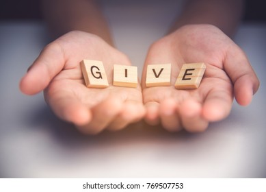 The word "GIVE" in hands in cupped shape. Concepts of sharing, giving, 
